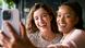 Two young women smiling brightly as they take a selfie together Two young women smiling brightly as they take a selfie together