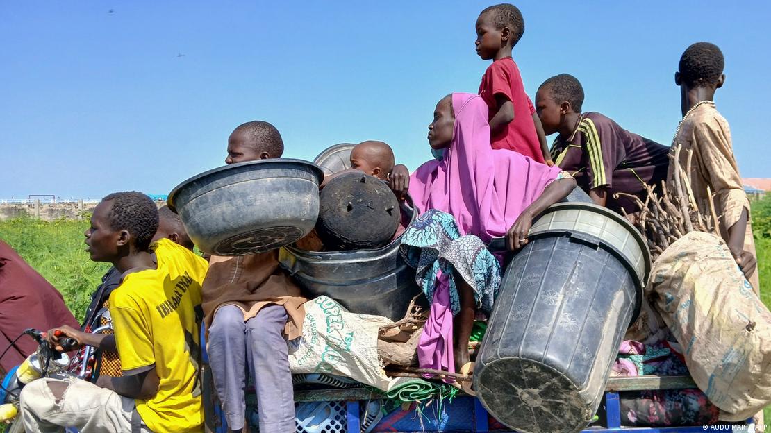 Familias con niños tratan de salvar algunas pertenencias tras las inundaciones en Borno, Nigeria. Las inundaciones ha destruido cientos de viviendas en Borno.