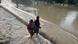 Two women walking through flood waters Two women walking through flood waters