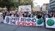 Protesters march behind a banner reading 'unite behind the science'