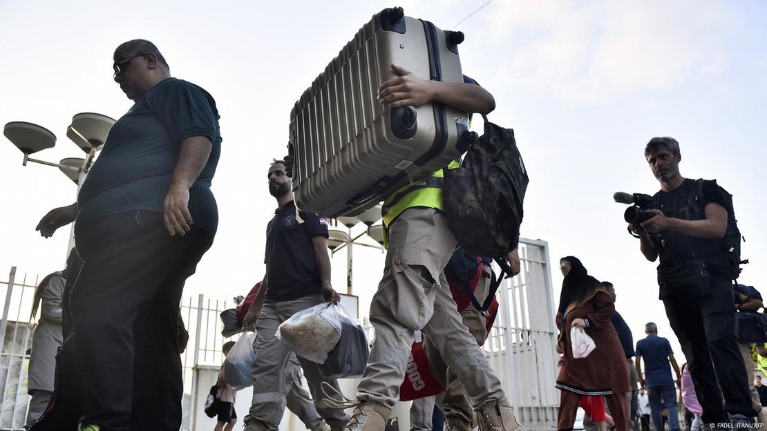  Lebanese fleeing their villages in southern Lebanon, carrying suitcases and bags.