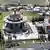 Aerial view of the Bektashi World Center in Tirana, Albania, April 23, 2024. In the middle, surrounded by trees, columns and decorative paving, is a domed, decorated, octagonal building with columns. In the background are buildings