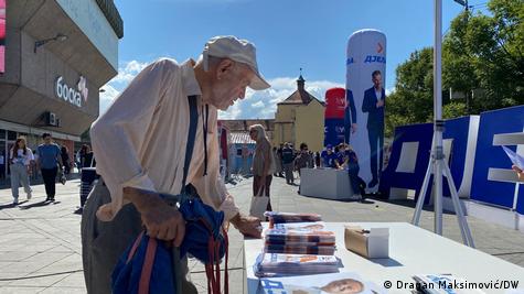 Stariji čovjek zainteresirano gleda brošure na jednom stranačkom predizbornom štandu Stariji čovjek zainteresirano gleda brošure na jednom stranačkom predizbornom štandu
