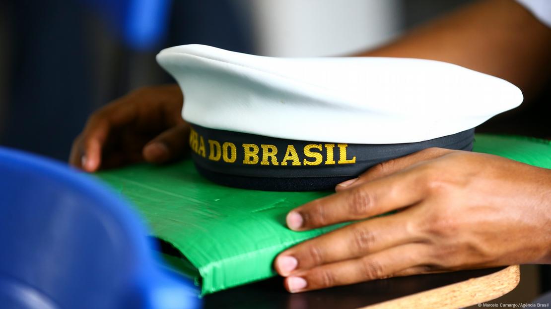 Mãos de jovem seguram boné da Marinha do Brasil