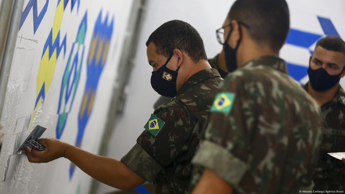 Militares pintam uma parede