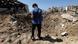 A person in a blue blue shirt and black pants inspects a crater at the site of an Israeli strike that hit the Lebanese seaside town of Jiyeh A person in a blue blue shirt and black pants inspects a crater at the site of an Israeli strike that hit the Lebanese seaside town of Jiyeh