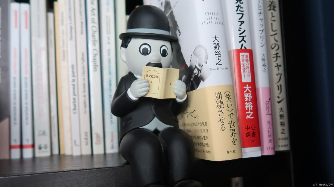 Boneco de Charlie Chaplin sentado numa estande de livros