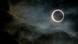 The moon blocks the sun during an eclipse, surrounded by dark clouds The moon blocks the sun during an eclipse, surrounded by dark clouds