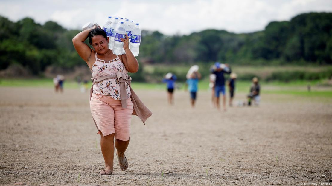 Mulher carrega pacote com garrafas de água