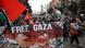 Tłum z flagami palestyńskimi i transparentem "wolna Gaza" idzie ulicą Berlina Tłum z flagami palestyńskimi i transparentem "wolna Gaza" idzie ulicą Berlina