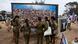Varia personas, entre ellas mujeres con uniforme militar, visitan el lugar del festival musical Nova, en Reim, Israel, donde los asistentes fueron asesinados y secuestrados durante el ataque terrorista perpetrado por Hamás desde Gaza el 7 de octubre de 2023.