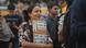 Rachita Taneja stands with a protest poster in a crowd