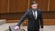 A man with a beard in a dark suit (MP Peter Kotlar) puts his hand on the constitution of Slovakia when he is sworn in in the Slovak parliament