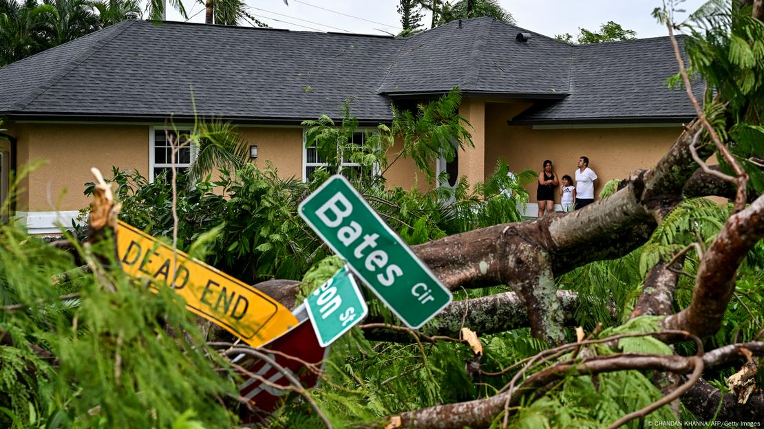 Entwurzelte Bäume und Straßenschilder liegen vor einem Haus im US-Bundesstaat Florida