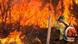 A firefighter works to put out fires in the Brasilia National Forest, facing a wall of flames A firefighter works to put out fires in the Brasilia National Forest, facing a wall of flames