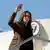 Kamala Harris waving from stairs as she boards Air Force Two plane