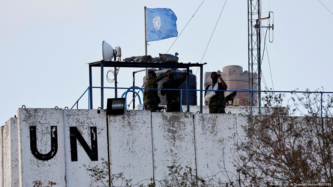 Três soldados em um posto de observação com a bandeira da ONU