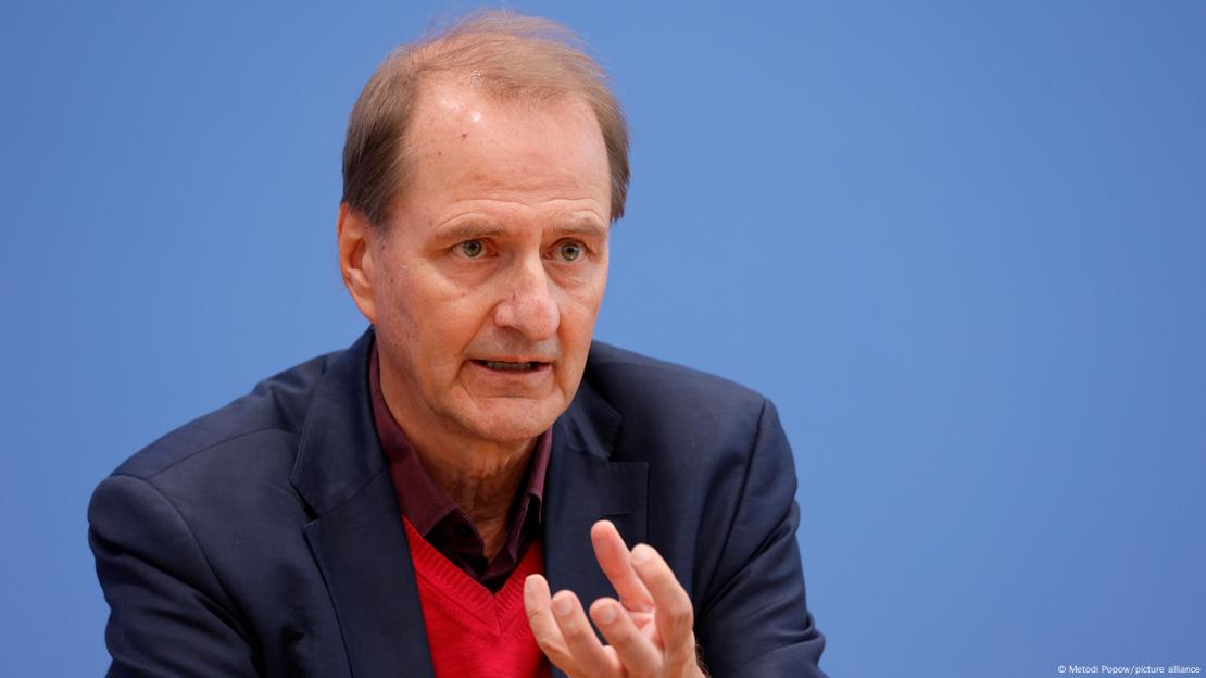 Dirk Messner, the head of Germany's Environment Agency, speaking in front of a blue background