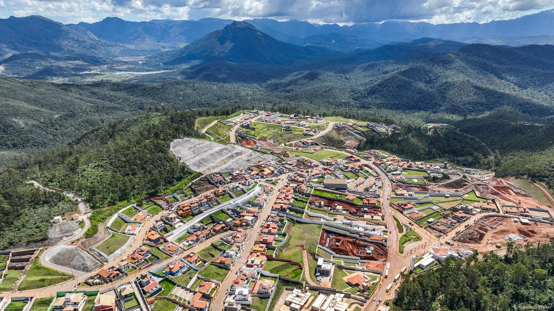 Imagem aérea do reassentamento Novo Bento Rodrigues, com montanhas ao fundo.