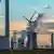 Chimneys from a brown coal power plant in Germany with windmills standing in front of the chimneys