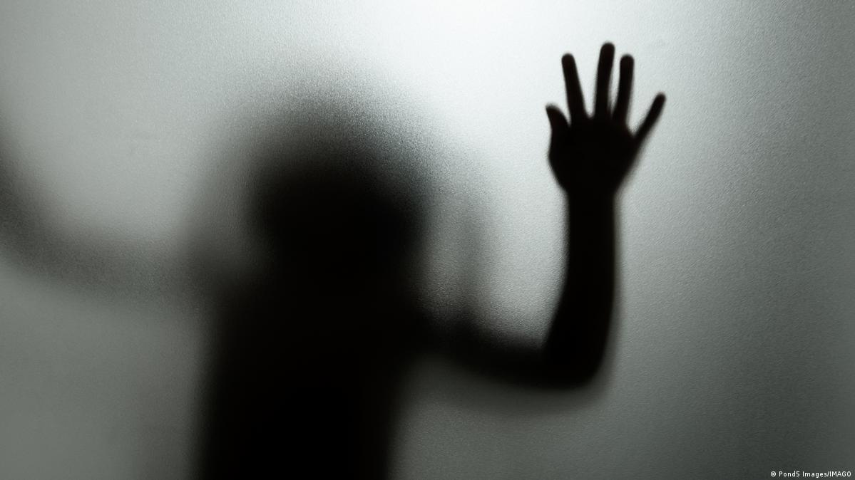 Ghost concept shadow of a child behind the matte glass blurry hand and body soft focus