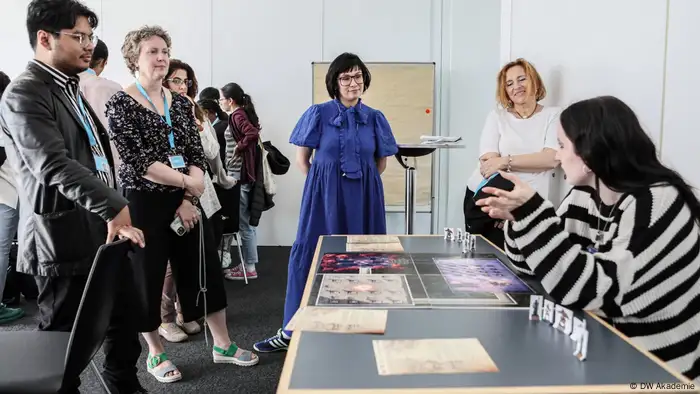 A group of people at DW headquarters in Bonn discuss an MIL game