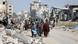Civilians seen walking down a dirty road amid rubble in Gaza Civilians seen walking down a dirty road amid rubble in Gaza