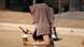 Mulher anda na rua com toalha na cabeça para se proteger do calor extremo Mulher anda na rua com toalha na cabeça para se proteger do calor extremo