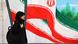 A woman walks past a mural painting of Iranian flags in a street in Tehran A woman walks past a mural painting of Iranian flags in a street in Tehran
