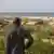 Homem observa mar - aquecimento e calor extremo