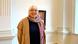 Eine weißhaarige Frau, Staatsministerin Claudia Roth, steht in einem Saal und schaut in die Kamera. Sie trägt einen beigen Mantel über einem dunkelblauen Wollpullover und einen bunten Schal um den Hals Eine weißhaarige Frau, Staatsministerin Claudia Roth, steht in einem Saal und schaut in die Kamera. Sie trägt einen beigen Mantel über einem dunkelblauen Wollpullover und einen bunten Schal um den Hals