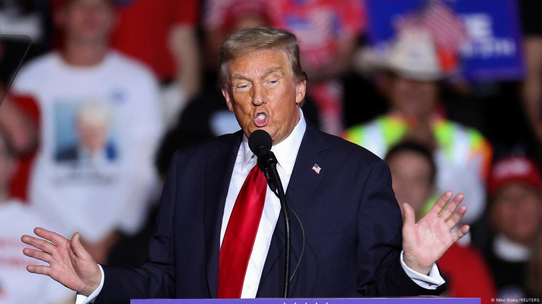 Donald Trump gjestikulon me duar para mikrofonit