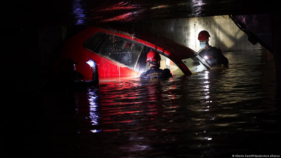 Servicios de rescate comprueban un auto en un aparcamiento inundado tras el paso del temporal. 