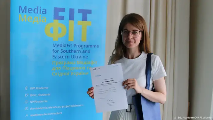 Anastasiia Rudenko holds up a certificate at an event in Bonn, Germany