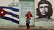 Mulher caminha em frente a mural com imagens de Che Guevara e da bandeira cubana Mulher caminha em frente a mural com imagens de Che Guevara e da bandeira cubana