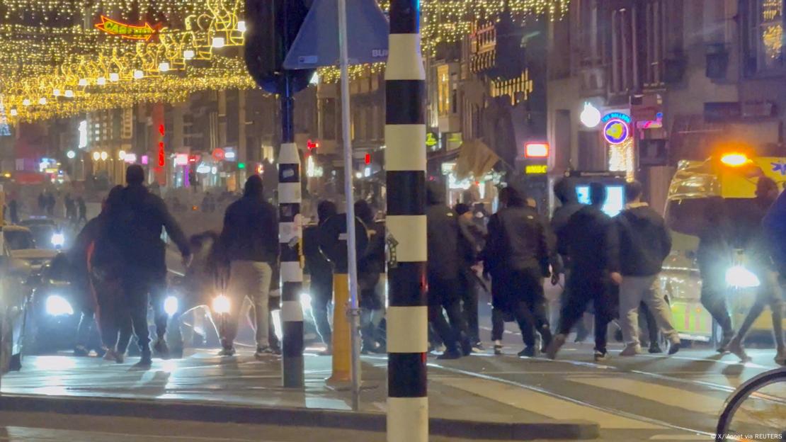 Enfrentamientos en Ámsterdam: personas vestidas de negro son fotografiadas de espaldas en una calle de Ámsterdam.