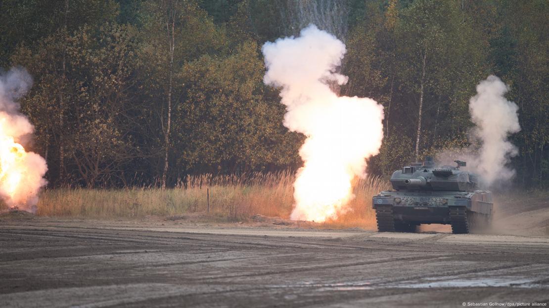 Ein Panzer vom Typ Leopard 2 der Bundeswehr fährt im Rahmen einer Ladeoperationsübung an explodierenden Granaten vorbei