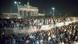 Hundreds of people gather at — and on — Berlin Wall with the Brandenburg Gate visible