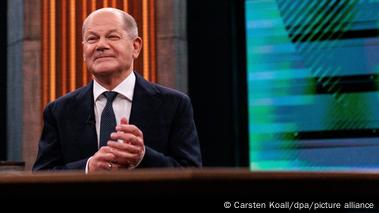 Olaf Scholz smiles and squints