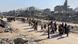 Palestinians walking through rubble in the Gaza Strip Palestinians walking through rubble in the Gaza Strip
