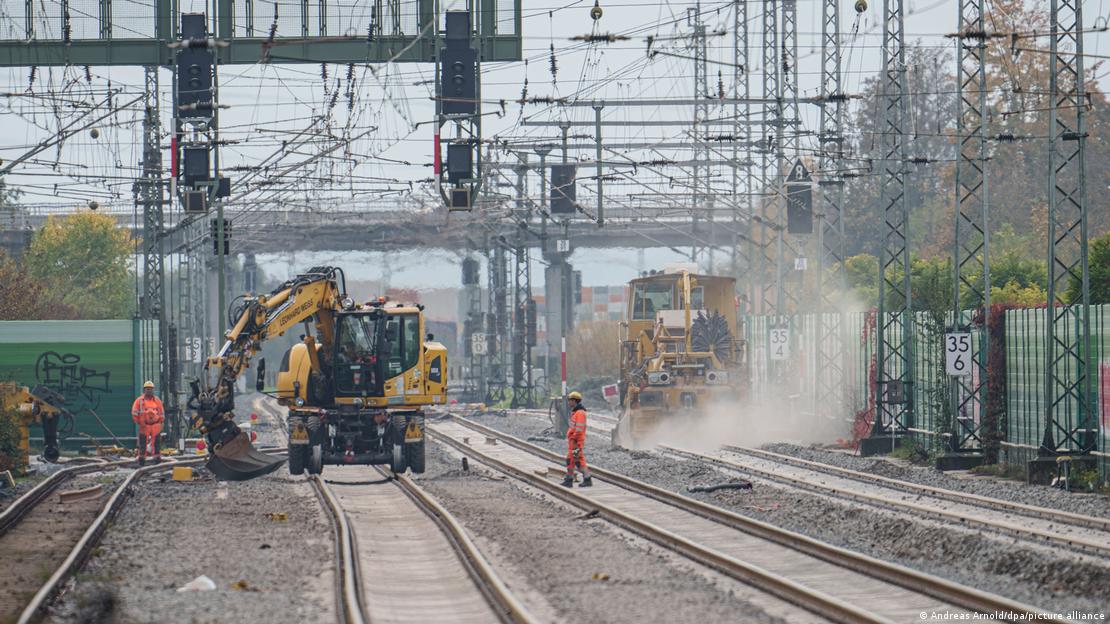 Fahrzeuge bei Bauarbeiten auf der Riedbahn, dazu Bauarbeiter Fahrzeuge bei Bauarbeiten auf der Riedbahn, dazu Bauarbeiter