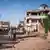 Women walk through a war-torn neighborhood in Omdurman