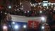 A street crowded with people shining their cell phone lights in the dark and holding up the flag of Slovakia and banners A street crowded with people shining their cell phone lights in the dark and holding up the flag of Slovakia and banners