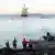 Workers stand on the shoreline as the C-Lion1 cable is laid between Rostock, Germany and Helsinki Finland