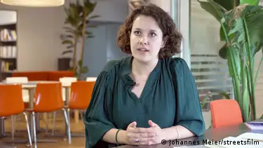 Cecilia Trasi sits at a desk, speaking