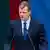 El primer ministro lituano, el socialdemócrata Gintautas Paluckas, frente a un micrófono y con una bandera del país de fondo.