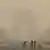 Women walk on a road near India Gate as the sky is enveloped with smog in November 2024