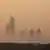 The tops of high-rise buildings in Karachi, Pakistan, just visible amid smog