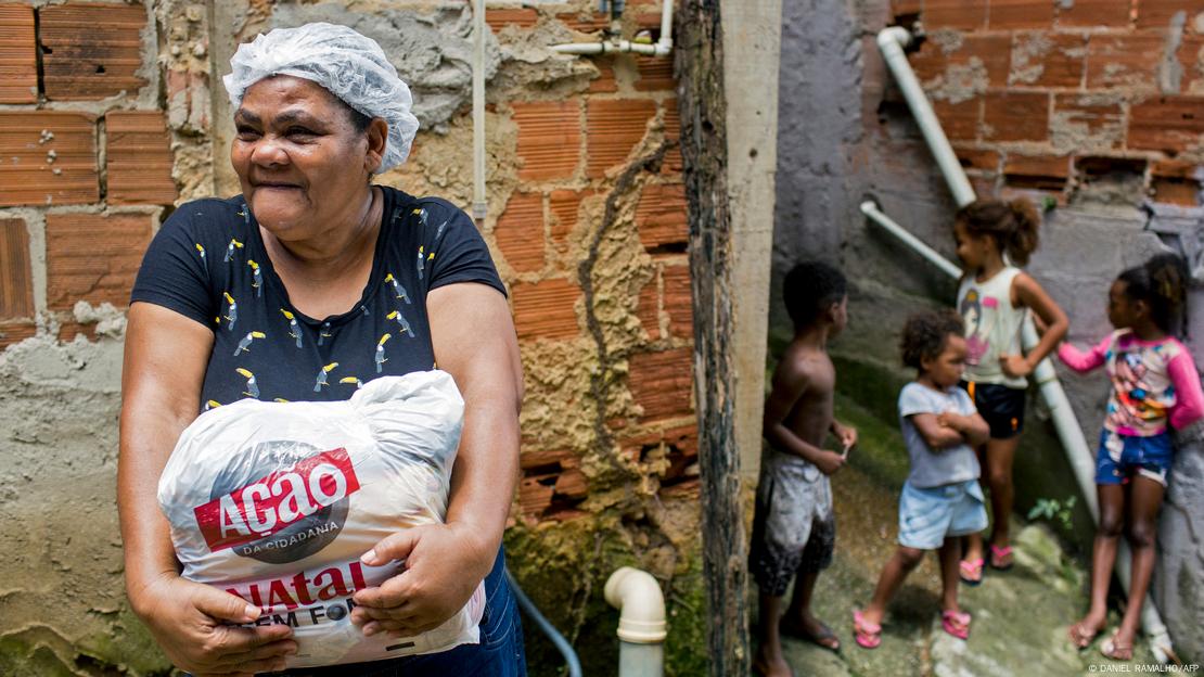 Mulher recebe sacola com mantimentos