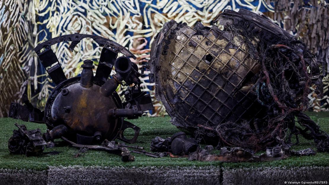 Restos chamuscados del fuselaje y el interior del misil, expuestos en una tienda de campaña militar de camuflaje.